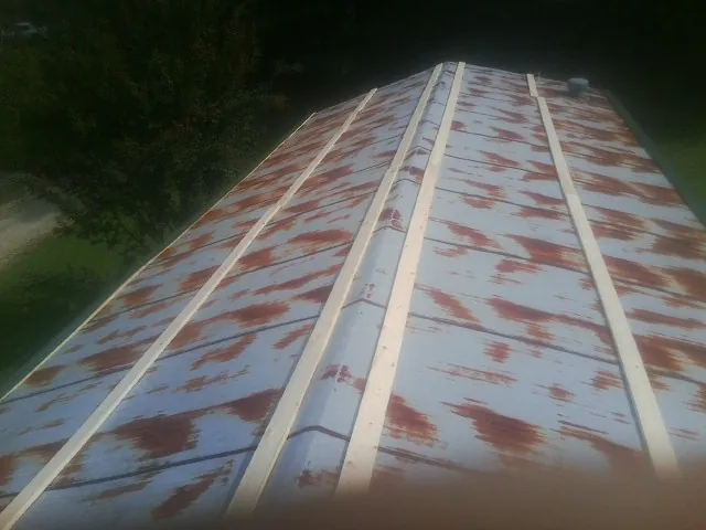 Rusted metal roof panels with new wood purlins before replacement — Storm Damage Roof Repair in Friend by Roofing Brothers