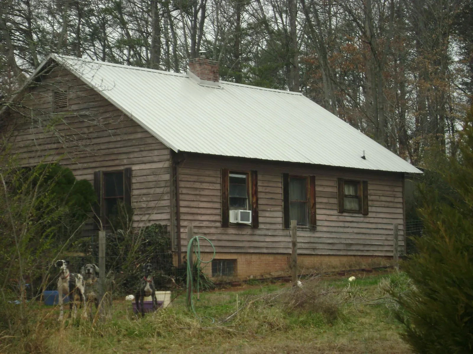 White metal roof on an old wood sided farmhouse in Friend